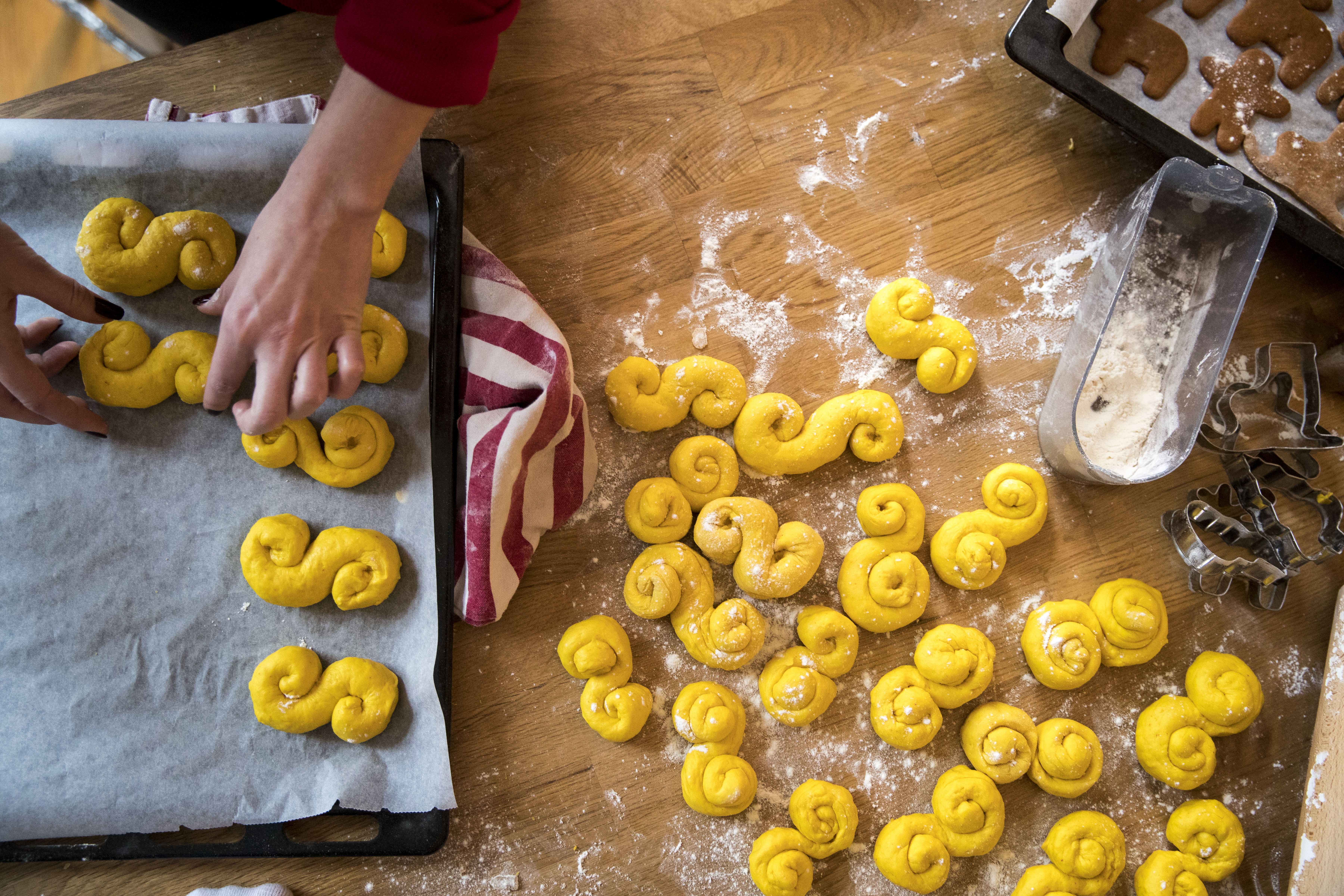 Händer bakar lussekatter och pepparkakor